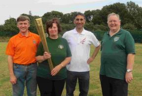 SADSAD Games - Lions President Marilyn holds and Olympic torch with the local torch bearer, Lion Iain and Lion Phil